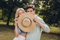 Portrait of two attractive funny flirty coquettish couple having fun romance hiding face behind cap on fresh air Royalty Free Stock Photo