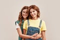 Portrait of two attractive young girls, twin sisters in casual wear smiling at camera, embracing, posing together Royalty Free Stock Photo