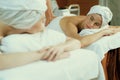 Two beautiful young woman having back massage. Front view. Tranquility. Royalty Free Stock Photo