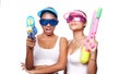 Beautiful Asian women in pink and blue sun visor cap and sunglasses posing with water guns over white background Royalty Free Stock Photo