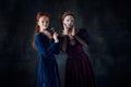 Portrait of two beautiful women in image of queen and princess applying face masks. Skin care routine Royalty Free Stock Photo