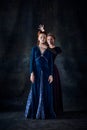 Portrait of two beautiful women in image of queens isolated over dark background. Envy, rivalry, intrigue Royalty Free Stock Photo