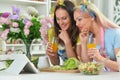 Two beautiful young women cooking together in kitchen Royalty Free Stock Photo
