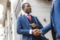 Portrait of two black African American businessman in suits shake hands outdoors. The joy of meeting good friends Royalty Free Stock Photo