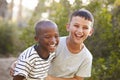 Portrait of two boys embracing and laughing hard outdoors Royalty Free Stock Photo