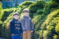 Portrait of two boys, siblings, brothers and best friends smiling. Friends hugging. Happy kids wearing warm closes in orangery par Royalty Free Stock Photo