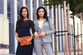 Portrait of two businesswomen dressed in a stylish formal clothes, standing in a downtown posing against a background of Royalty Free Stock Photo