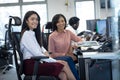 Portrait of two businesswomen sitting on desk at modern office Royalty Free Stock Photo