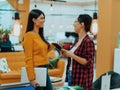 Portrait of two businesswomen talking to each other while standing in a modern business office with their colleagues Royalty Free Stock Photo