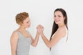 Portrait of two casual young female friends arm wrestling Royalty Free Stock Photo