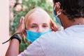 Portrait of two Caucasian and African girls in protective masks, coronavirus concept. teenage girl adjusts her friend`s medical Royalty Free Stock Photo