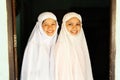 Portrait of two charming Muslim teenage girls in traditional clothing smiling at camera