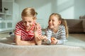 Portrait of two cheerful children laying on the floor and playing with colorful dices Royalty Free Stock Photo