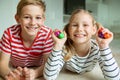 Portrait of two cheerful children laying on the floor and playing with colorful dices Royalty Free Stock Photo