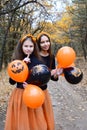 Portrait of two cheerful girls with black and orange balloons in the Halloween style