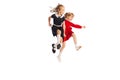 Portrait of two cheerful girls, children jumping over puddle, running isolated over white studio background. Playful Royalty Free Stock Photo