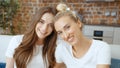 Portrait of two cheerful teenage girlfriends looking at camera and smiling.