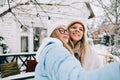 Portrait of two cheerful women friends standing outdoor in the backyard and taking selfie photo Royalty Free Stock Photo