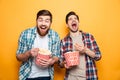 Portrait of a two cheerful young men eating popcorn Royalty Free Stock Photo