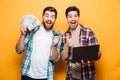 Portrait of a two cheerful young men holding laptop Royalty Free Stock Photo