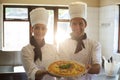 Portrait of two chef presenting a pizza Royalty Free Stock Photo