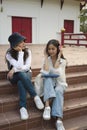 Two college students  sitting on stairs in college campus and talking after their class. Royalty Free Stock Photo