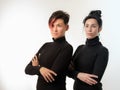 Portrait of two confident women in black clothes standing side by side  over white background Royalty Free Stock Photo