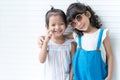 Portrait of two cute Asian and Caucasian little girls friends hug each other, smiling, posing in studio white background. Children Royalty Free Stock Photo