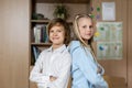 Portrait of two cute caucasian young blond little classmate friend kids eating apple in classroom at lunch time pause