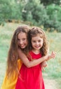 Portrait of Two Cute little girls embracing and laughing at the countryside. Happy kids outdoors