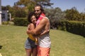 Portrait of two diverse male and female friends embracing at a pool party Royalty Free Stock Photo