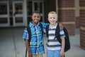 Portrait of Two diverse school kids standing outside their elementary school building Royalty Free Stock Photo