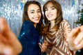 Portrait two dressy pretty women making selfie on Christmas or New Year party