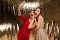 Portrait of two excited cheerful women in sparkly dresses Royalty Free Stock Photo