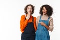 Portrait of two excited women hugging and pointing finger Royalty Free Stock Photo