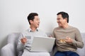 Portrait of a two excited young men holding laptop computer while pointing finger at a credit card and celebrating Royalty Free Stock Photo