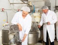 Bakery workers watching work of kneading machine Royalty Free Stock Photo