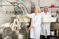 Bakery workers watching work of kneading machine Royalty Free Stock Photo