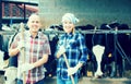 Portrait of two farmers near cows barn