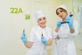 Portrait of two female diagnostic laboratory scientist in medical uniform holding blood test tubes standing on hallway Royalty Free Stock Photo