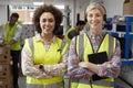 Portrait Of Two Female Workers Using Headsets In Distribution Warehouse With Digital Tablet Royalty Free Stock Photo
