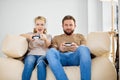 Portrait of two friends playing video games at home. Lifestyle and technology concept. Royalty Free Stock Photo