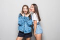 Portrait of a two girls gossip on gray background Royalty Free Stock Photo