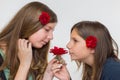 Portrait of two girls smelling red rose