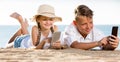 Smiling kids on beach with phone in hands Royalty Free Stock Photo