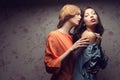 Portrait of two gorgeous girlfriends in blue and orange dresses