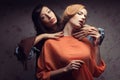 Portrait of two gorgeous girlfriends in blue and orange dresses Royalty Free Stock Photo