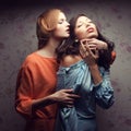 Portrait of two gorgeous girlfriends in blue and orange dresses