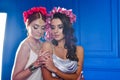 Portrait of the two gorgeous ladies with wild flowers. Elegance. Wreaths Fantasy