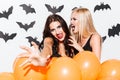 Portrait of two gothic beautiful young women with orange balloons